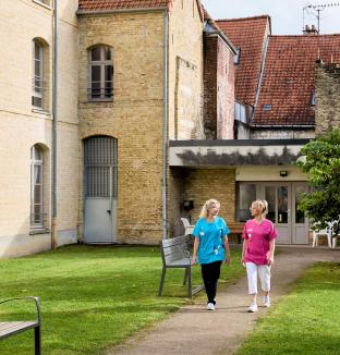 Deux soignantes marchent dans la cour