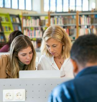 Eleve et professeur dans une bibliothèque