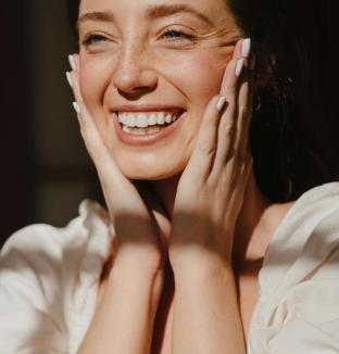 Femme souriante face au soleil