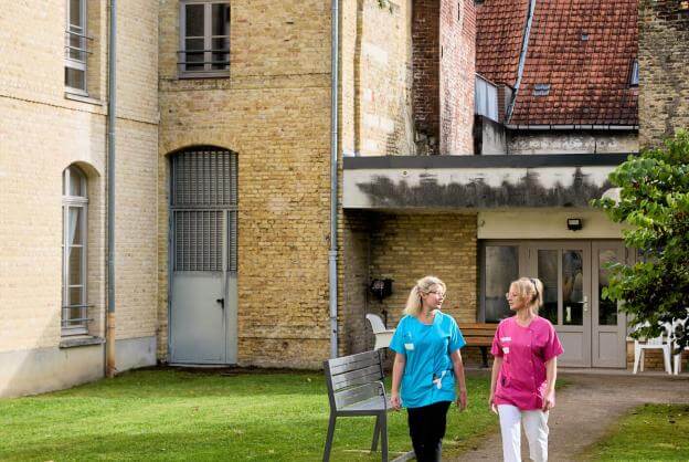 Deux soignantes marchent dans la cour