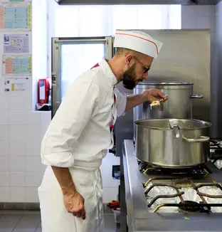 Cuisinier en train de goûter un plat
